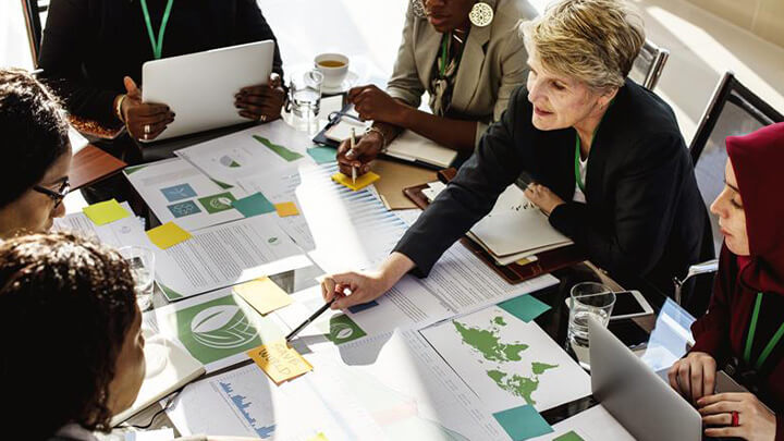People around a desk looking through documents