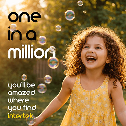 A young girl smiling as she runs through bubbles blowing in the field